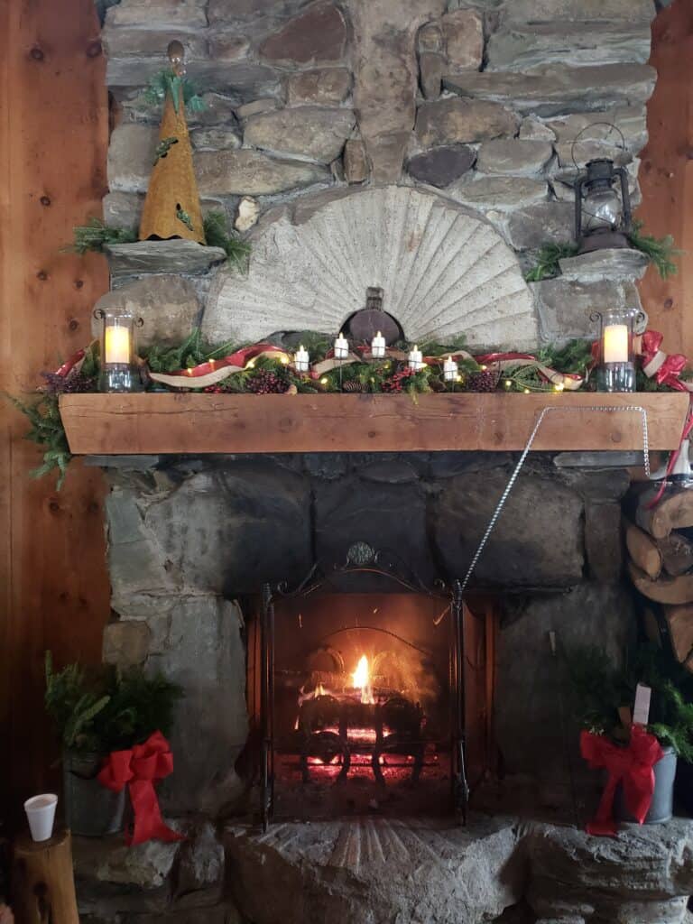 a lit fireplace decorated for christmas