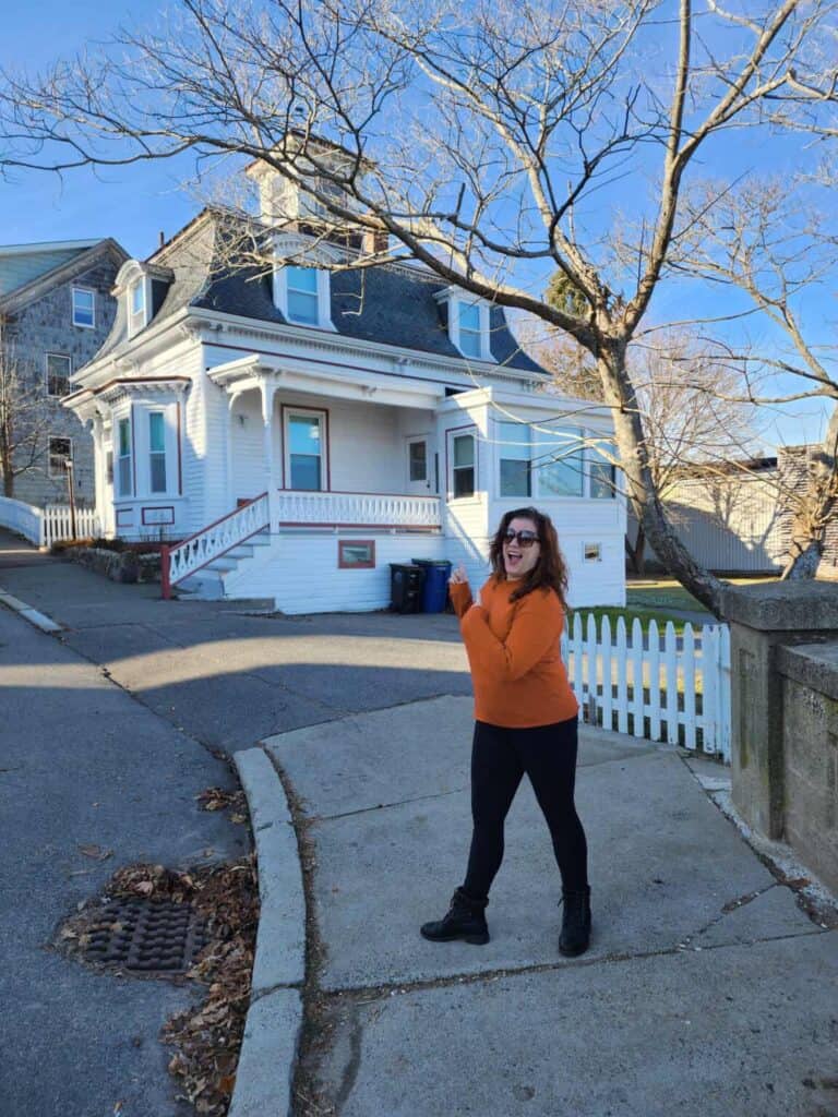 A woman stands in front of a Hocus Pocus filming site in Salem, Massachusetts