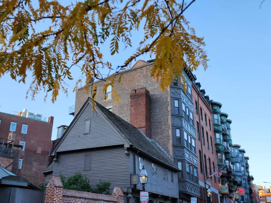 The historic Paul Revere House, nestled in Boston's North End, framed by autumn leaves, is a captivating landmark and one of the essential places to go in Boston for a walk through history.