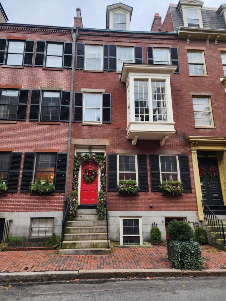 Exterior of a Boston brownstone made of red brick and decorated with wreaths and bows for Christmas 