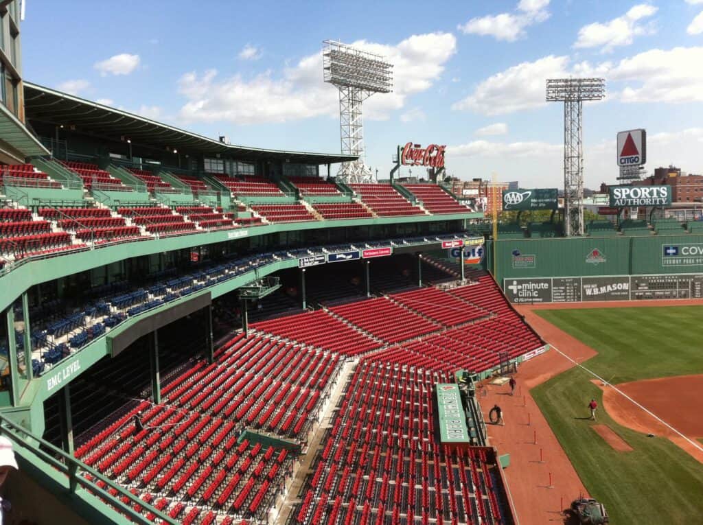 Sunny day view of the iconic Fenway Park in Boston, with its green diamond and rows of red seats, a key highlight for any sports fan's Boston bucket list