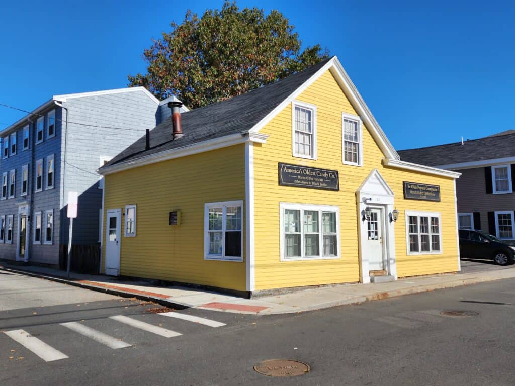 A bright yellow historic building that is home to the oldest candy company in America