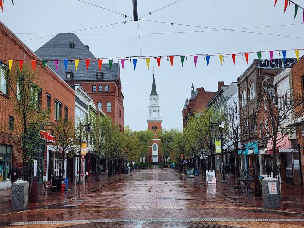 A wide shot of Church Street Marketplace in Burlington, Vermont with the church at the far end and streets wet with rain