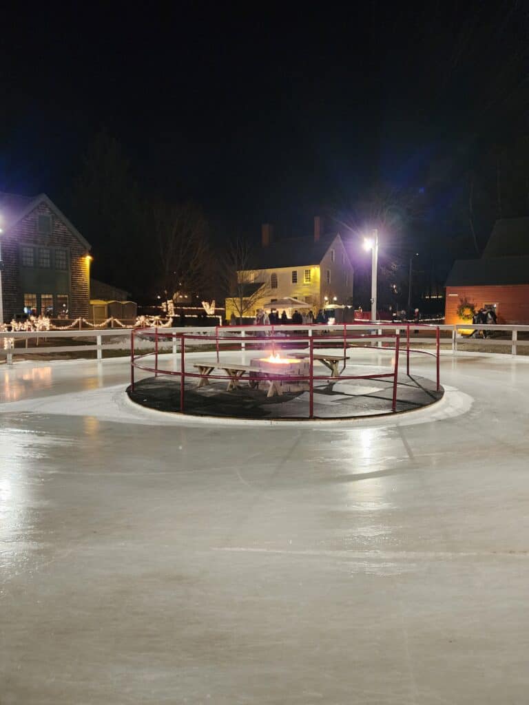 The ice skating pond at Puddle Dock Pond in Portsmouth, New Hampshire at night  with a firepit seating area in the middle