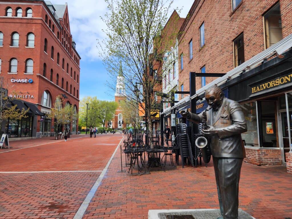 image of a bricked walkway in downtown burlington vermont, with a statue of a saxophonist in the foreground